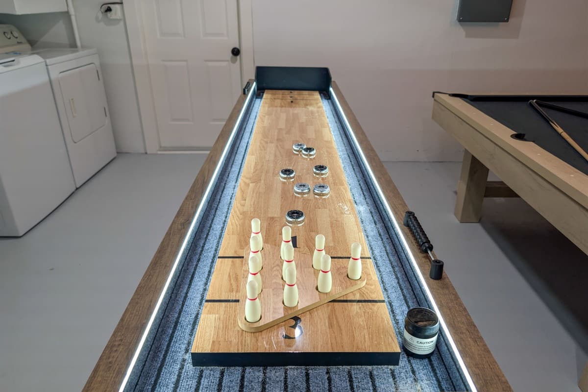 Game on! This versatile recreation room doubles as a home gym, complete with cardio equipment, free weights, and multiple game tables for family fun.