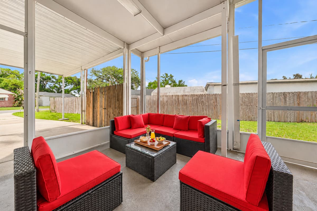 Screened-in patio with cozy seating and views of the private fenced backyard.