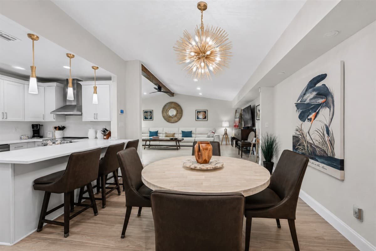 Bright and spacious dining area with contemporary lighting, breakfast bar seating, and open-concept layout.