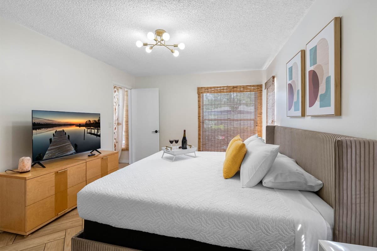 With mid-century modern decor, soft lighting, and crisp linens, this serene master bedroom offers a king bed, dedicated workspace, and private ensuite bath—perfect for both work and relaxation.