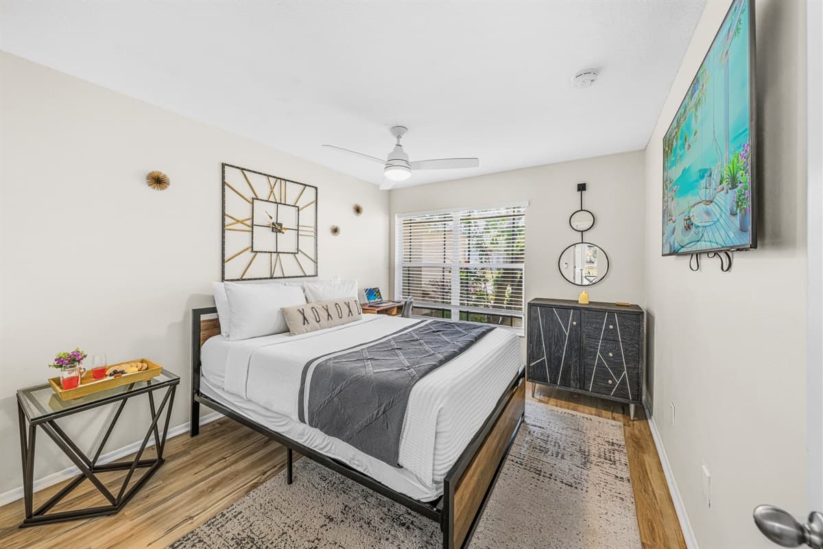 Comfortable guest bedroom with a queen bed, Smart TV, and plenty of natural light.