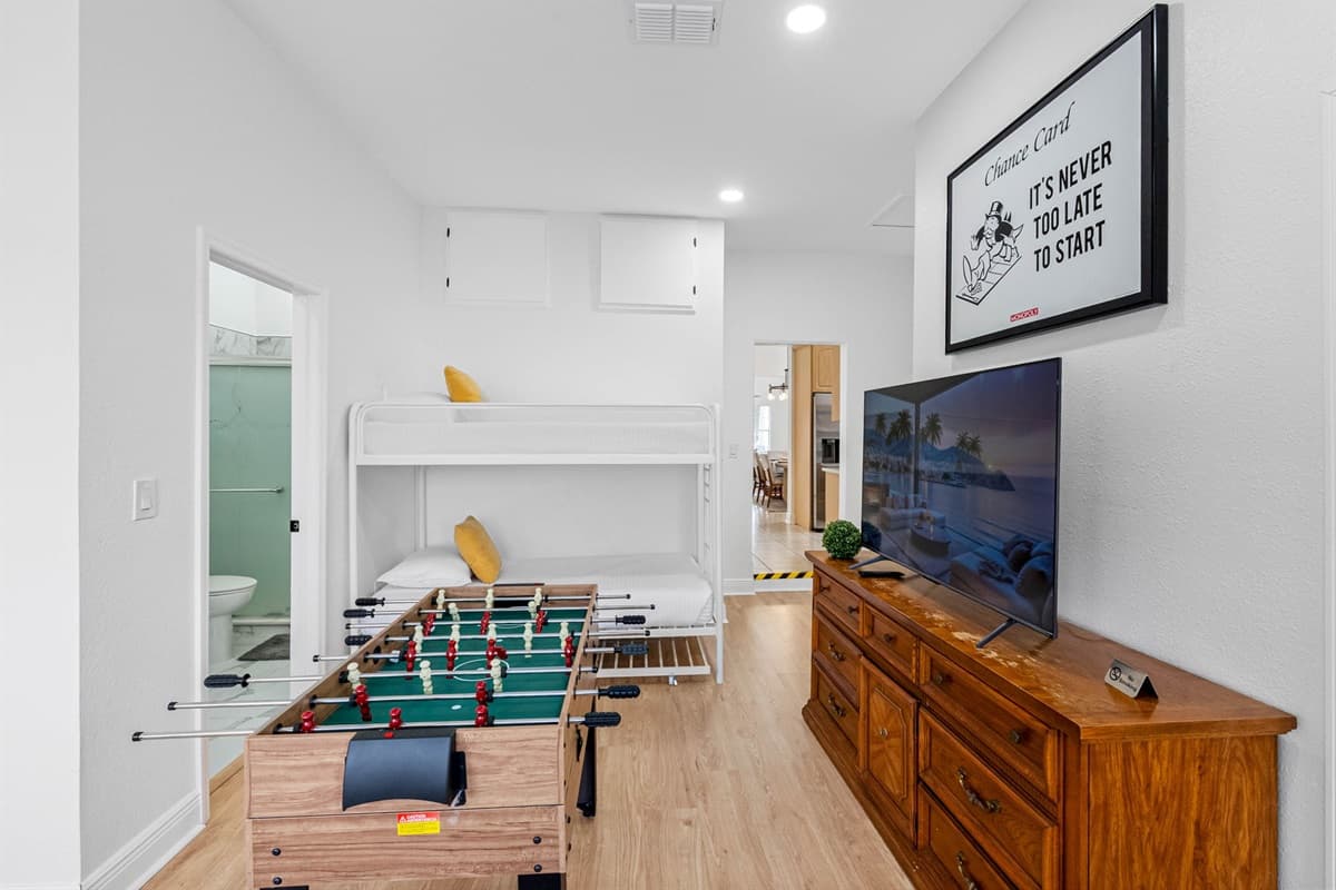 A casual and comfortable space designed for downtime, featuring a TV, foosball table, and sleeping accommodations all in one room.