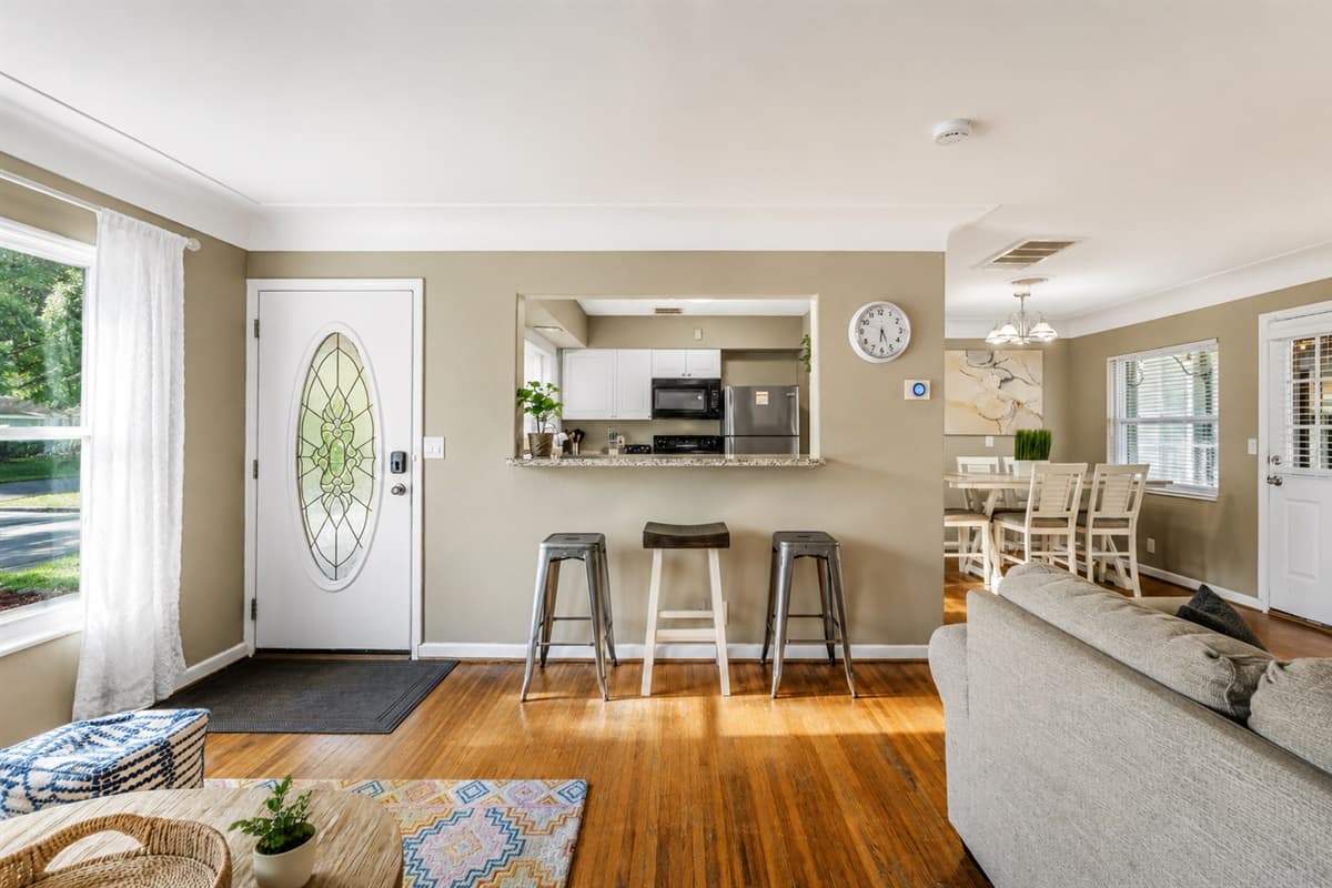 Welcoming entryway with breakfast bar seating and an open-concept layout connecting the kitchen and living room.