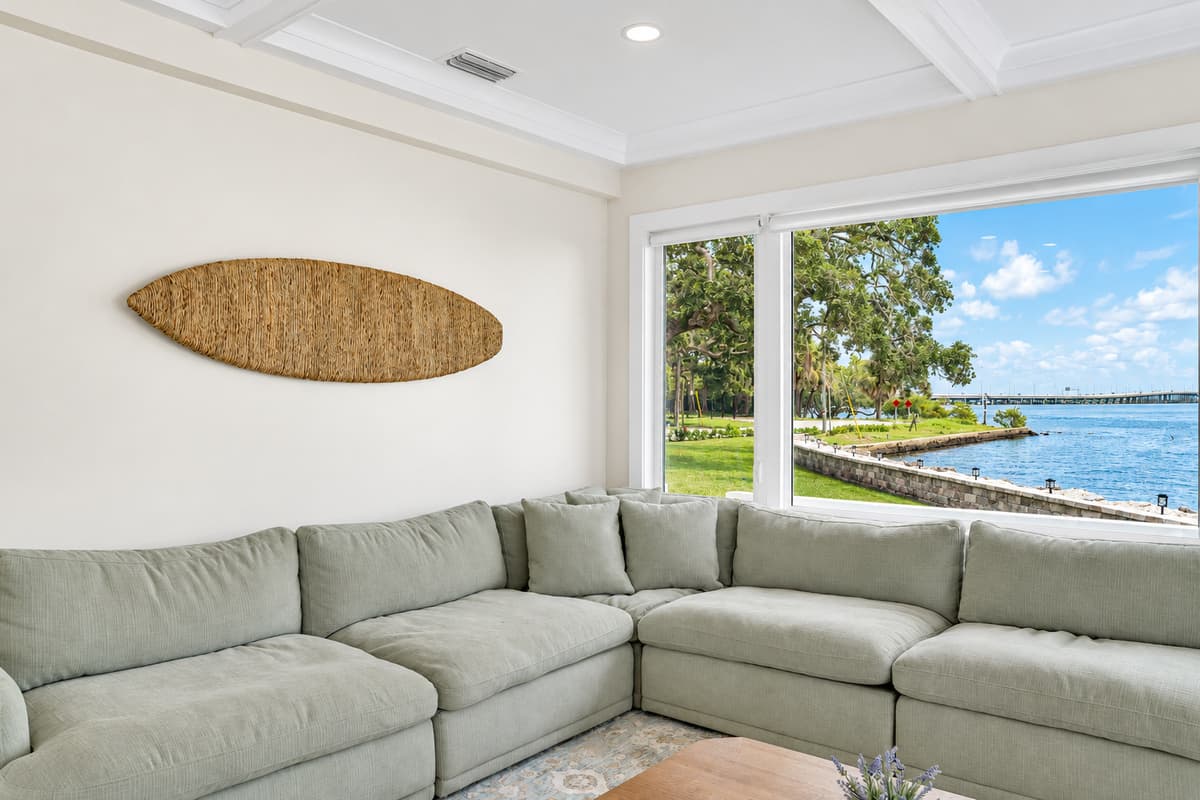 Window seat for the whole group. A long sectional runs under wide windows facing the bay. Everyone gets a seat and a view.