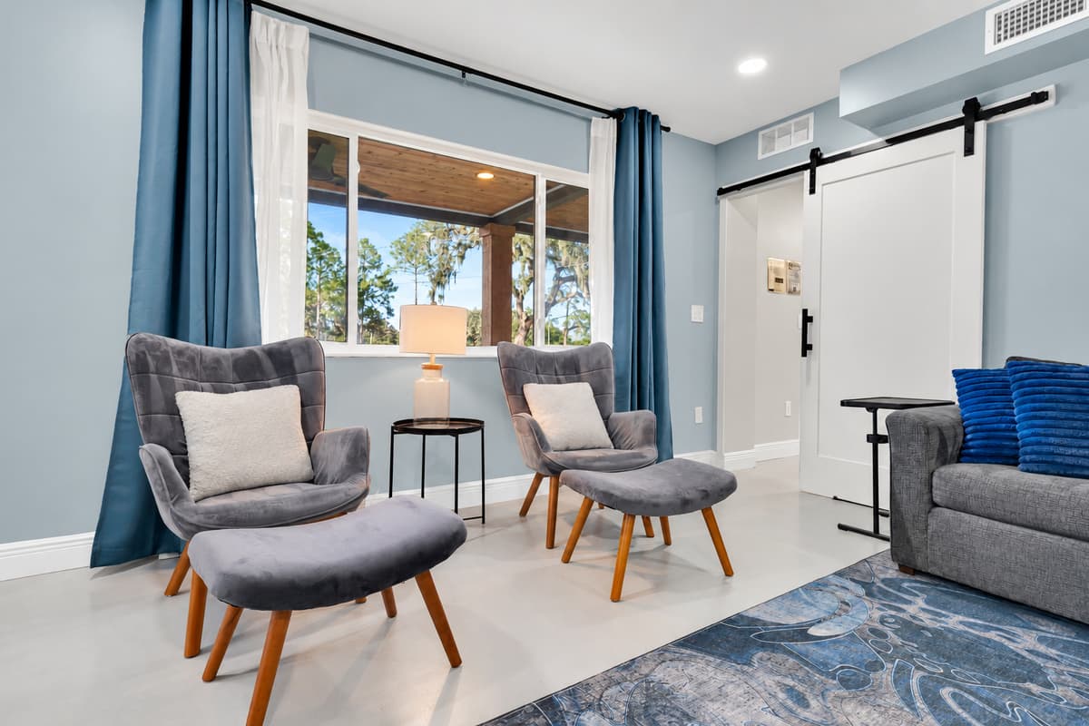 Two armchairs, a window, and nobody bothering you. A small sitting area set apart from the main rooms — the corner for reading, a phone call home, or ten minutes alone.