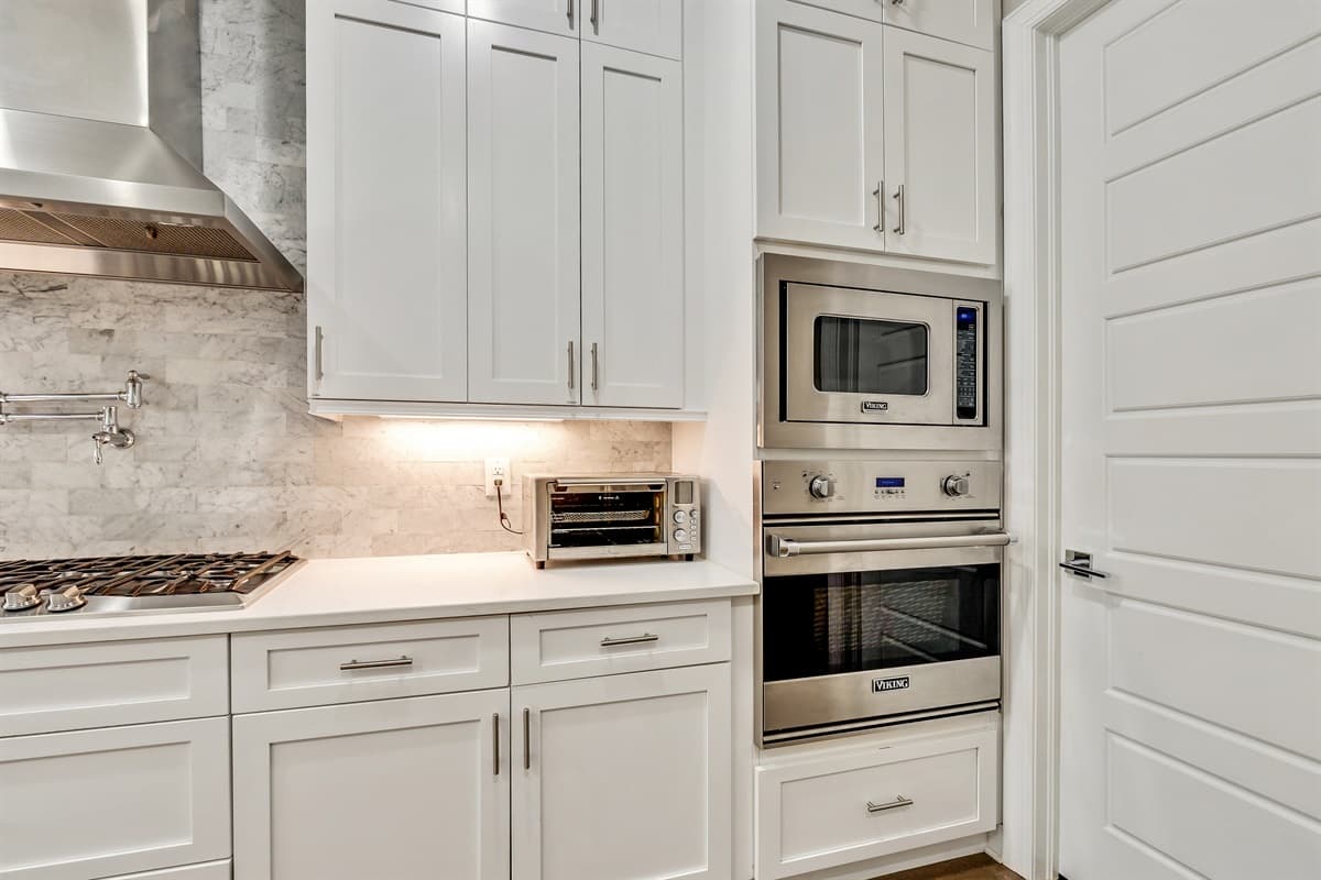 The stainless steel appliances stand ready to assist, from the state-of-the-art oven to the versatile cooktop, ensuring that every dish is cooked to perfection.