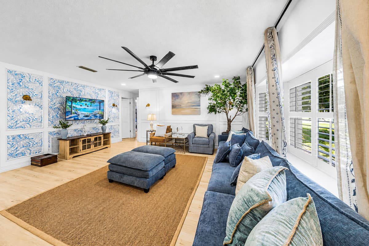 Plantation shutters, ceiling fan, jute rug — the room stays cool and bright straight through the afternoon.