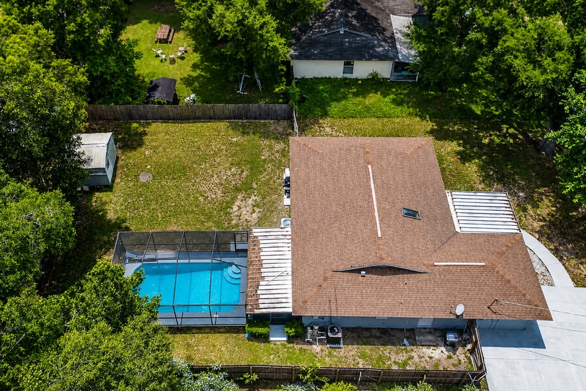 Aerial side profile of the property showcasing the beautiful fully fenced backyard, our immaculate heated pool and spacious driveway. If you are interested in this property, send us an inquiry as soon as possible!