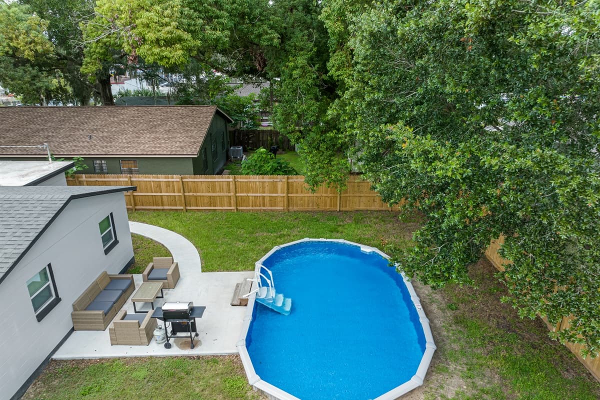 The top aerial view of our beautiful property showcasing the beautiful fully fenced backyard and the stunning heated pool. Enjoy the view outside showcasing beautiful trees in the area. Don't hesitate and book this property now!