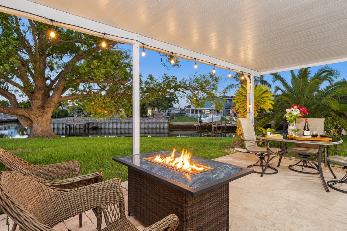 As evening falls, string lights cast a warm glow over the patio, creating a magical ambiance for dinner parties or quiet moments by the fire pit.