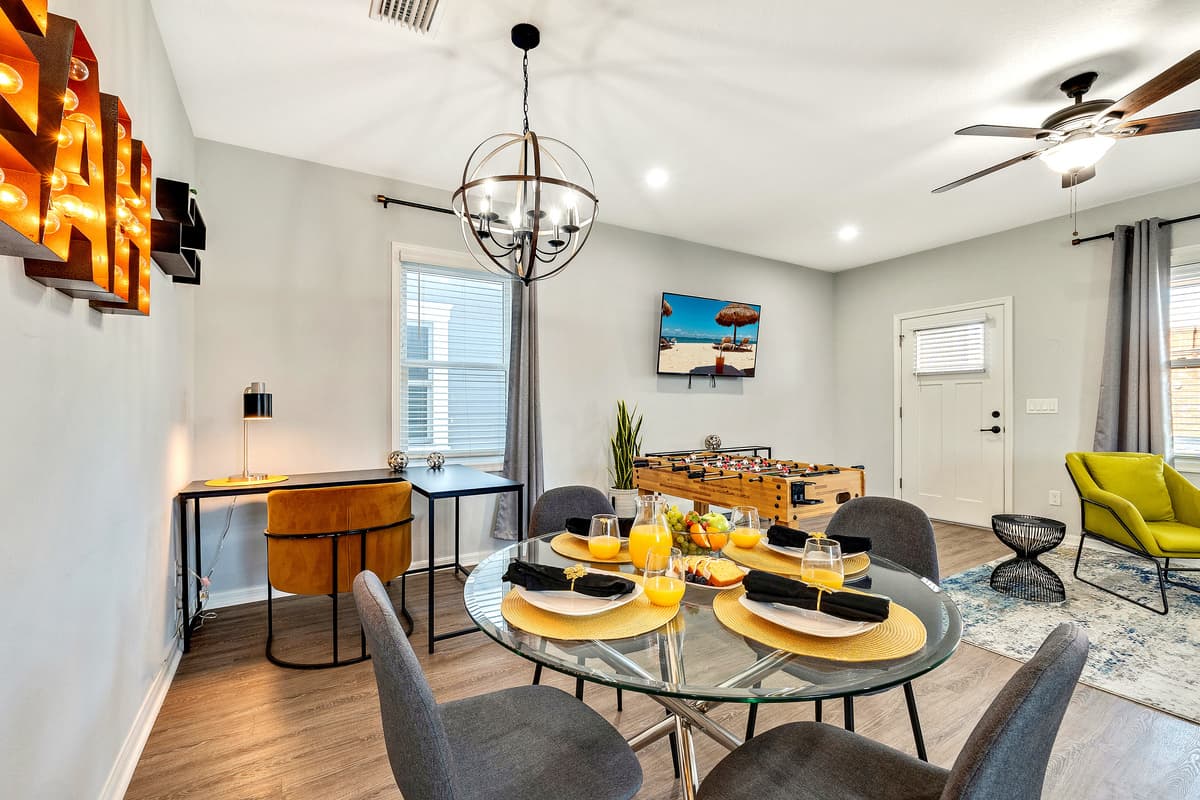 Natural light spills in through nearby windows, casting a gentle glow over the elegant 4-seater table and creating a warm and inviting ambiance.
