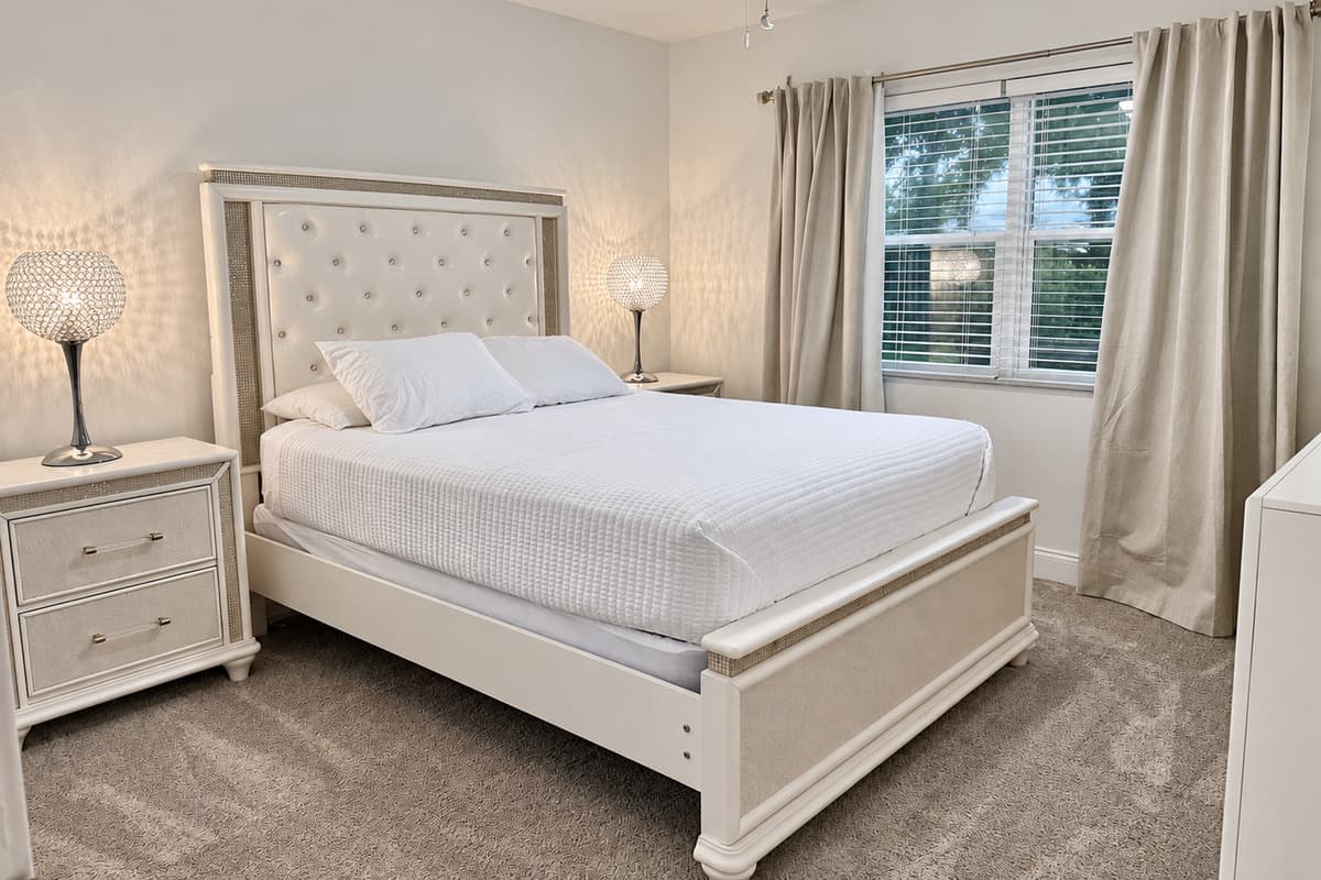 Drift off in this peaceful bedroom oasis, featuring rich textures, soft bedding, and plenty of natural light.