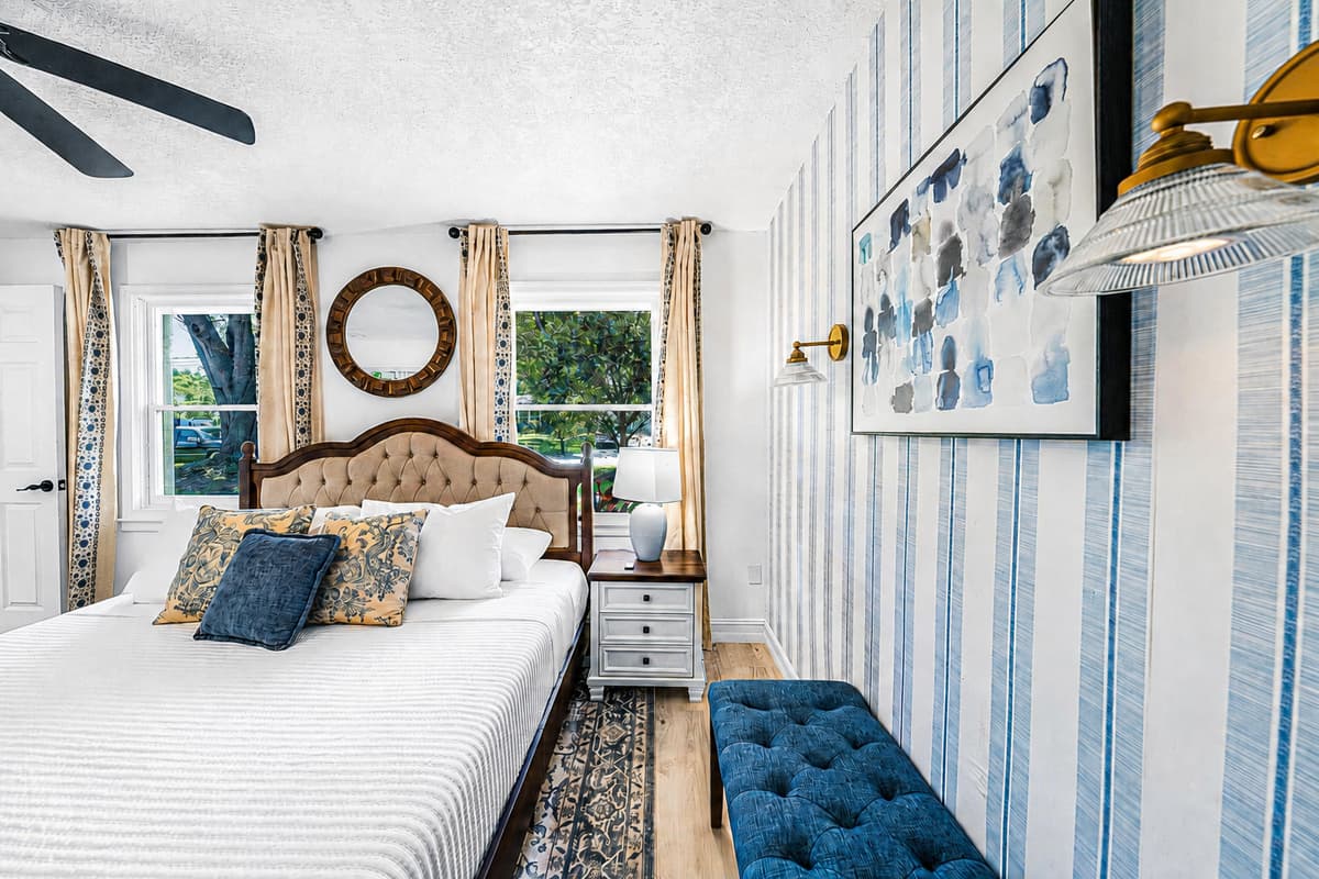 Queen bed, bench at the foot for the suitcase, window on each side. The room is ready before you open the bag.