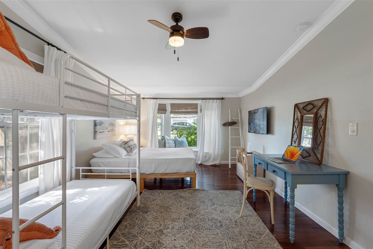 Stylish yet functional bedroom with white walls, crown molding, and warm hardwood floors.