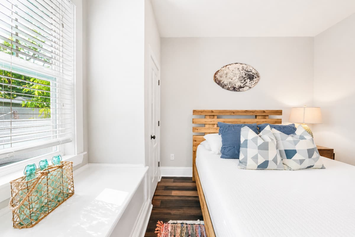 A bright and inviting bedroom featuring a comfortable queen-size bed, soft linens, and plenty of natural light.