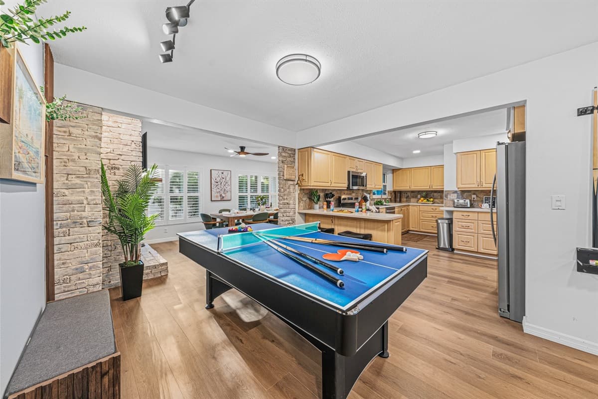 Large open layout showcasing the game area flowing into the kitchen and living spaces 