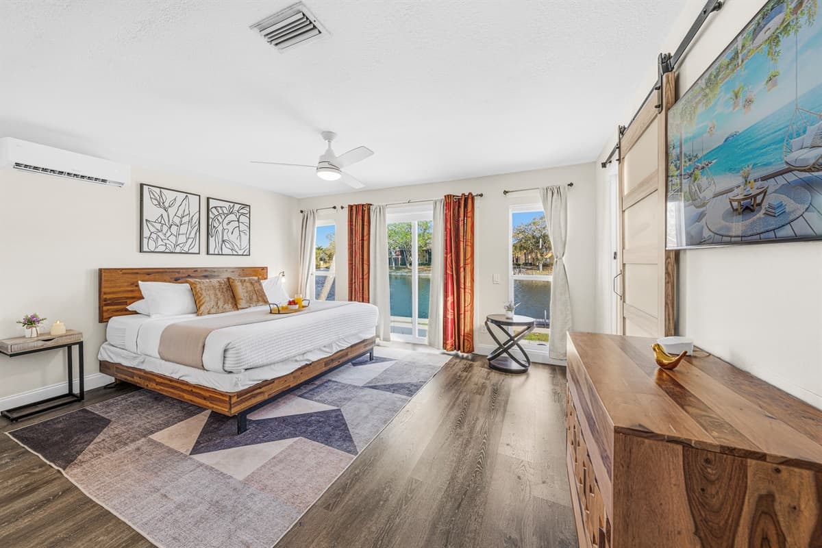Relax in the spacious primary bedroom featuring a king bed and peaceful waterfront views.
