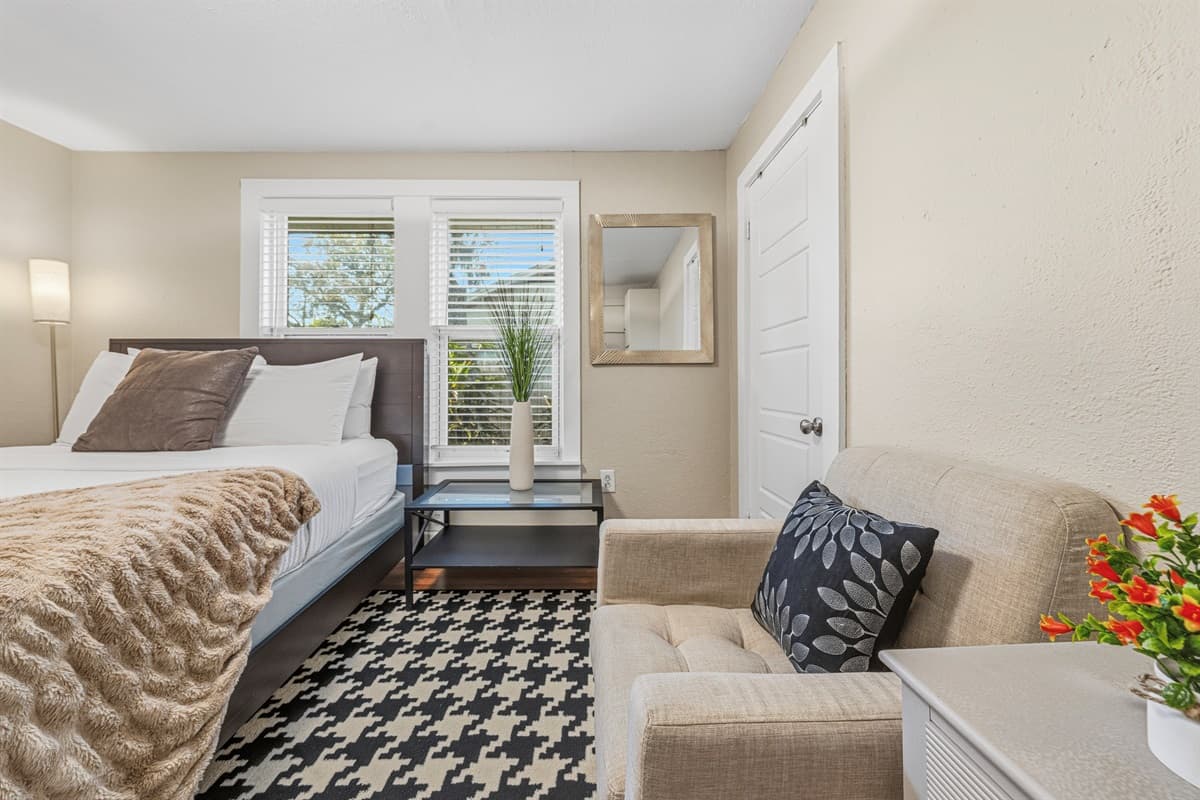 Cozy bedroom with a seating nook and warm, inviting décor.