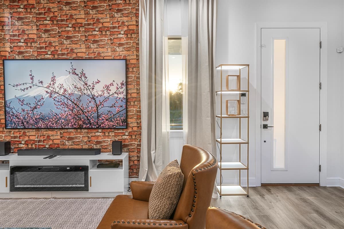 Close-up of the entertainment wall with a mounted TV, fireplace feature, and stylish brick backdrop.