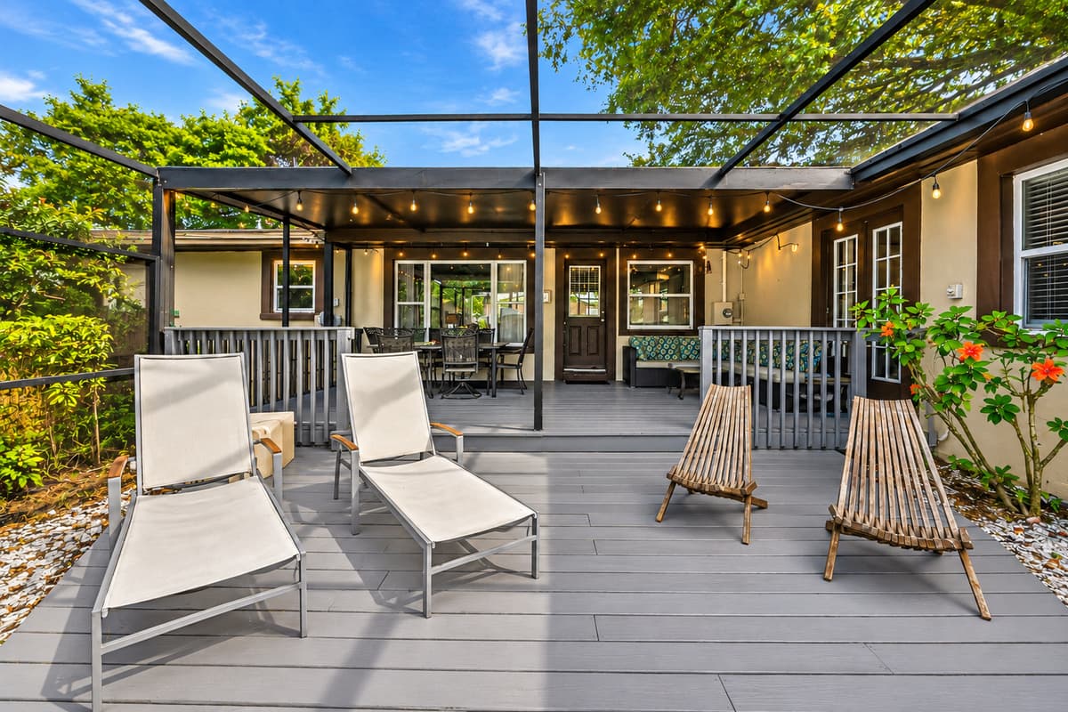 Expansive outdoor living area featuring lounge chairs, covered seating, and a resort-style atmosphere.