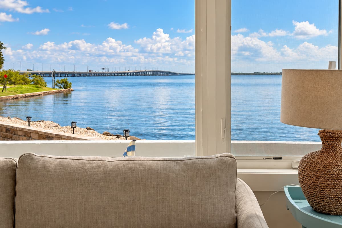 Waterfront living room with comfortable seating and wide water views.