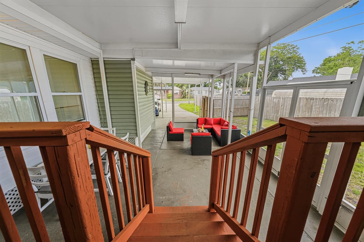 Entry view from patio steps leading into a large covered outdoor living space.