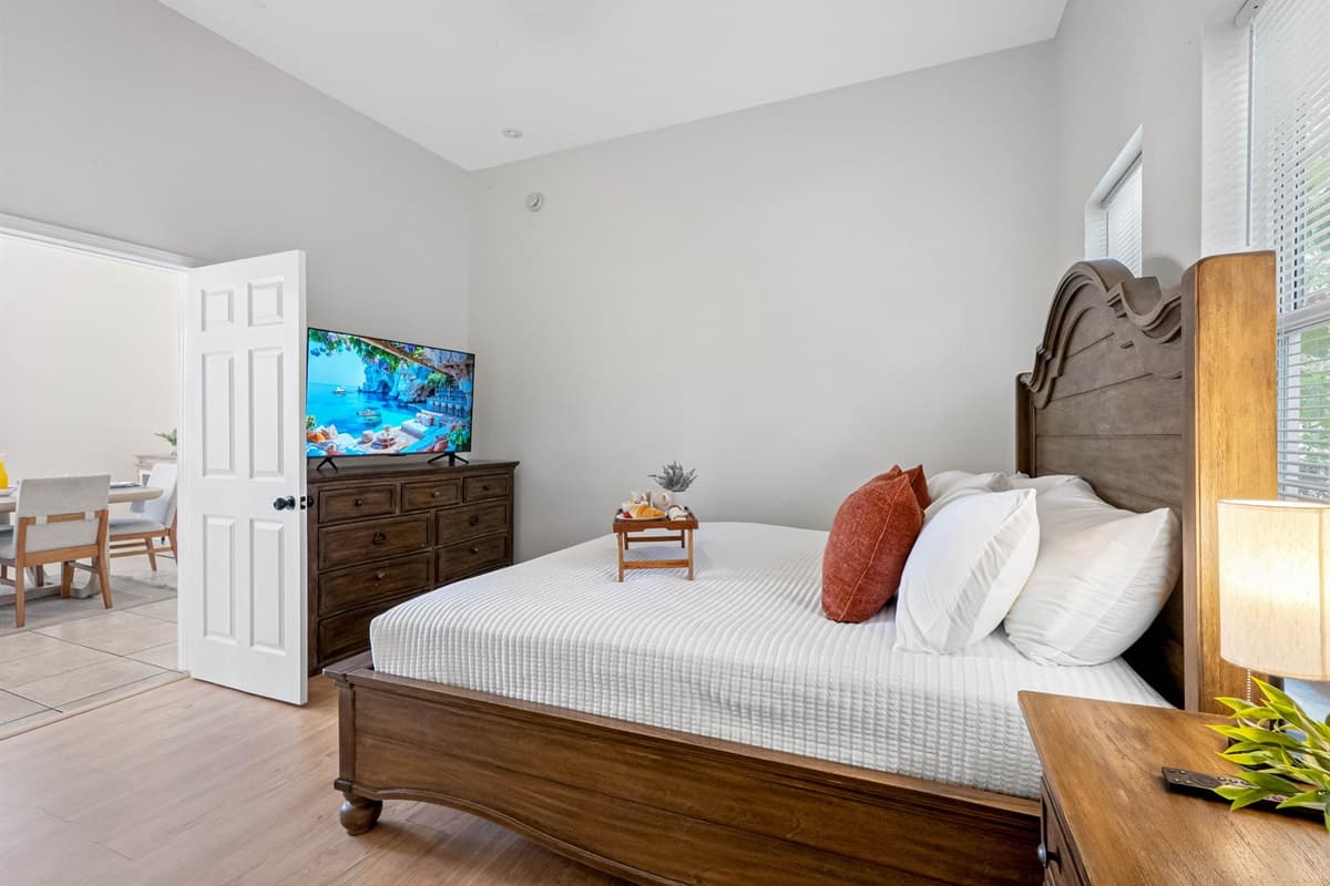 Designed for comfort and simplicity, this bedroom includes a plush mattress, elegant wood furniture, and a serene, neutral color palette.
