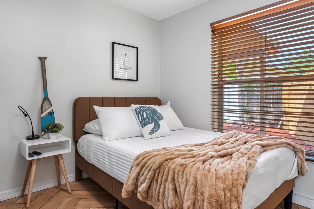 This thoughtfully furnished bedroom offers everything you need for a cozy stay—full bed and a bunk bed, stylish lighting, and wall art.