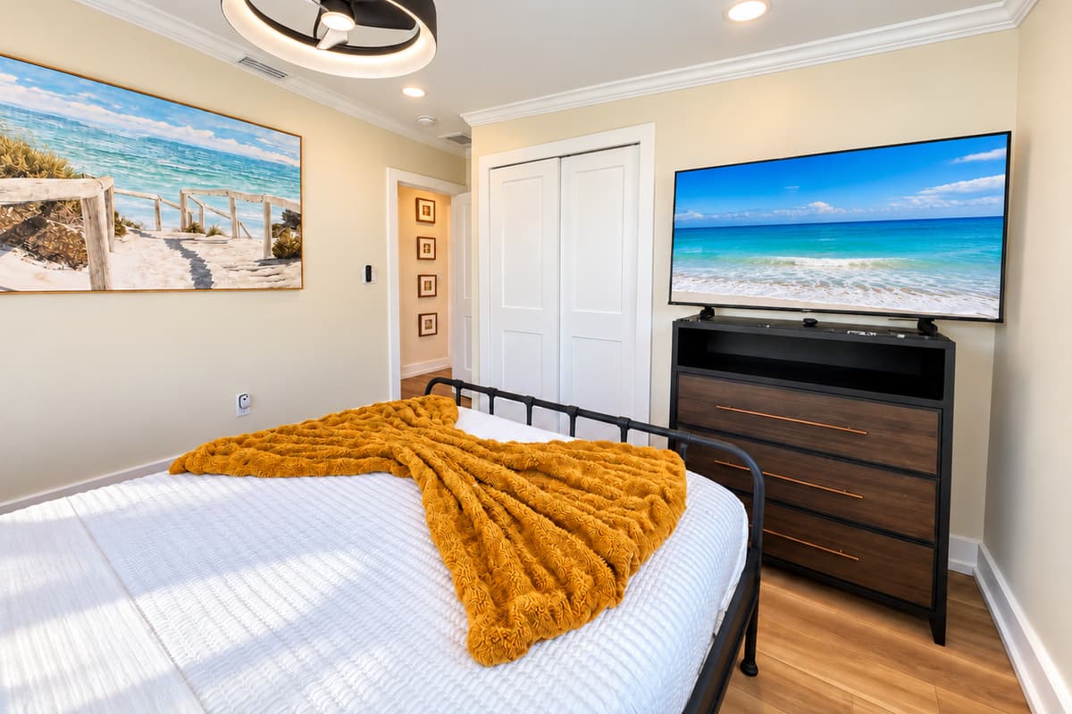 Queen bedroom with a smart TV and dresser.
