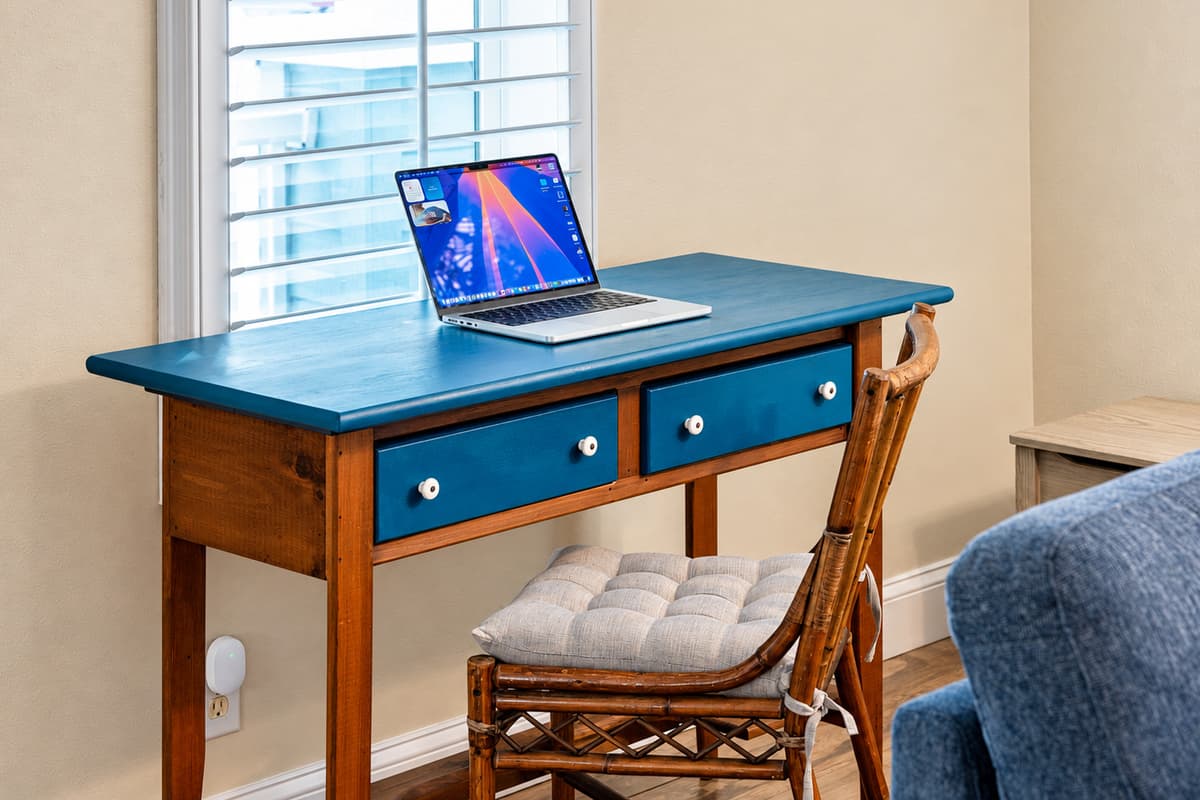 A cozy workspace is tucked into the living area, complete with a colorful desk, comfortable seating, and bright natural light—perfect for remote work, studying, or planning your adventures.