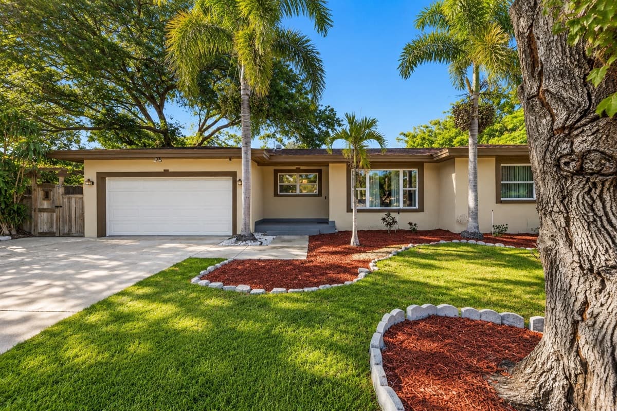 Beautiful exterior view featuring a large driveway, palm trees, and landscaped yard.