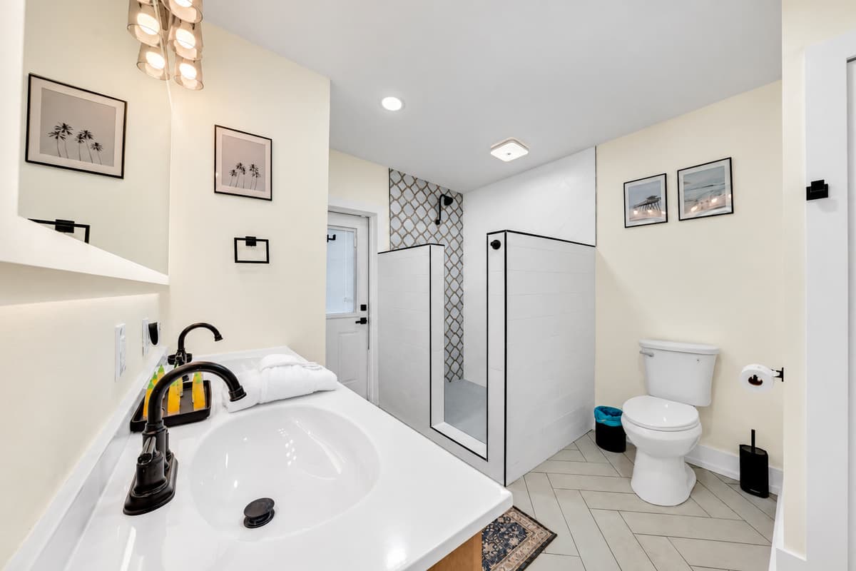 A clean, modern bath with a walk-in shower. Bathroom 1 has a black-fixture vanity, patterned tile and a walk-in shower. Fresh, bright and ready for you.