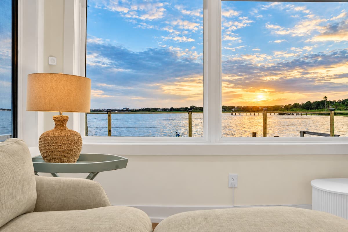Sunset through the living room windows. The sun sets right over the bay while you relax on the sofa. Stay in, stay comfy and still catch the show.