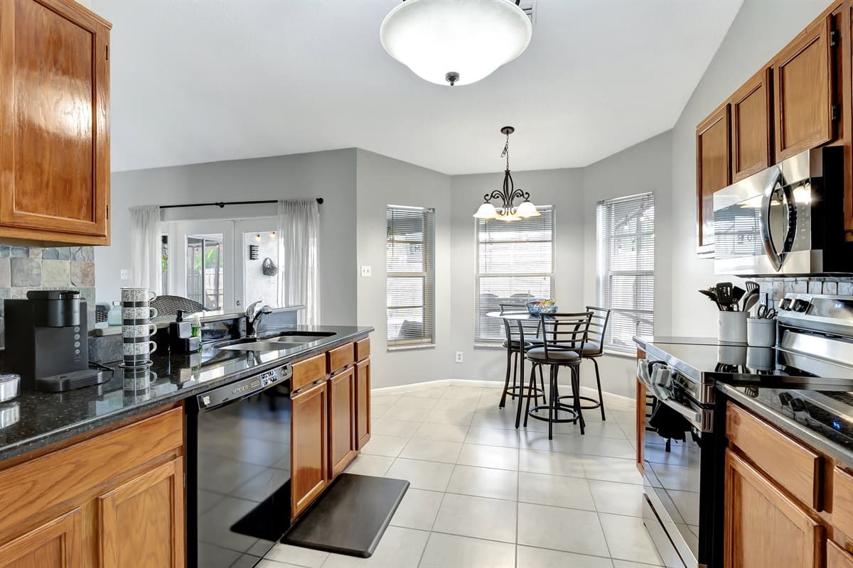 Adorned with rich wooden cupboards and a gleaming black countertop that exudes modern chic.
