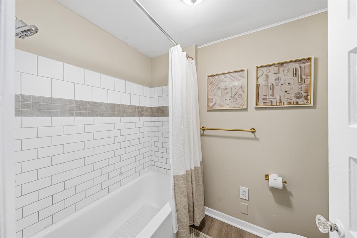 Full bathroom featuring a shower/tub combo and fresh, clean design.