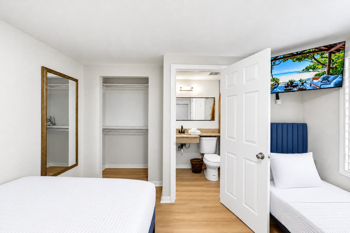 This thoughtfully designed connected bedroom suite comfortably accommodates multiple guests. The first room features one queen-size bed, while the connecting room offers a queen-size bed, a twin bed, and a private ensuite bathroom.