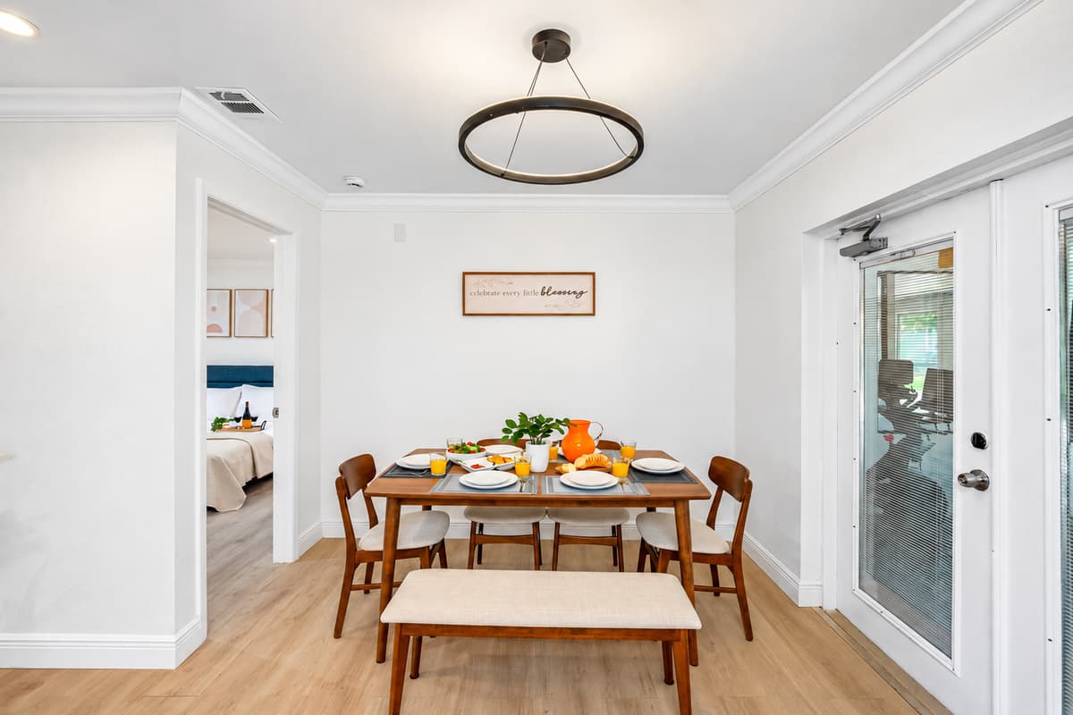 Modern wood tones, clean lines, and a pop of color from the centerpiece make this dining area effortlessly chic.
