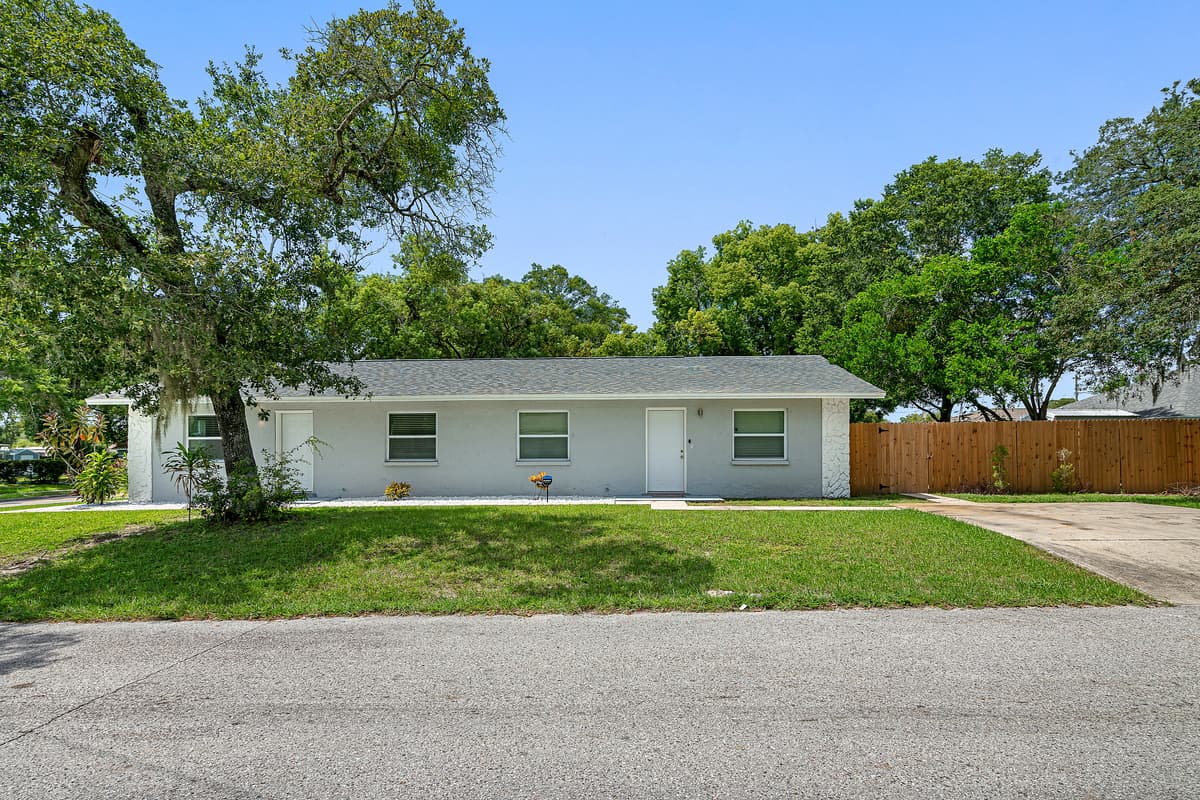 The lovely side view of the house showcasing the beautiful facade of the proeprty, amazing tree, and driveway. If you are interested in this property, send us a message! Book now!