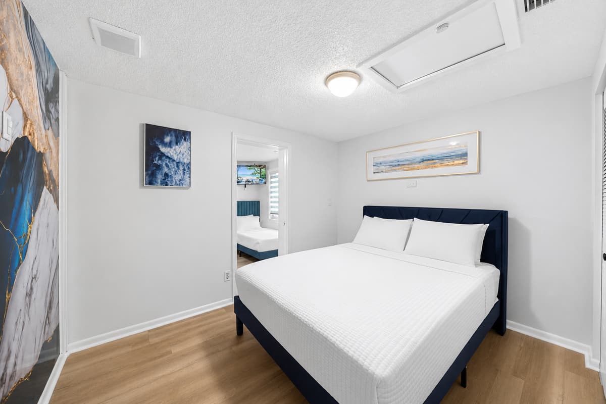 Spacious primary suite with comfortable king bed, contemporary design, and direct access to the ensuite bathroom.