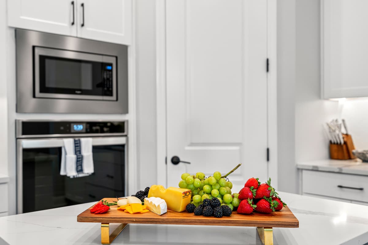 The stainless steel finish of the appliances contrasts beautifully with the white cabinetry, adding a touch of sophistication to the space.