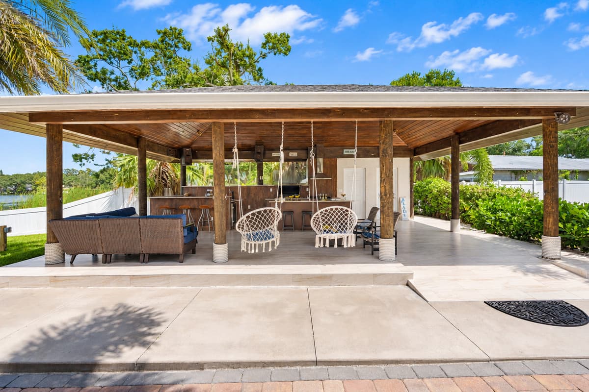The patio flows seamlessly into the lush green yard and waterfront, creating a resort-style atmosphere right at home.