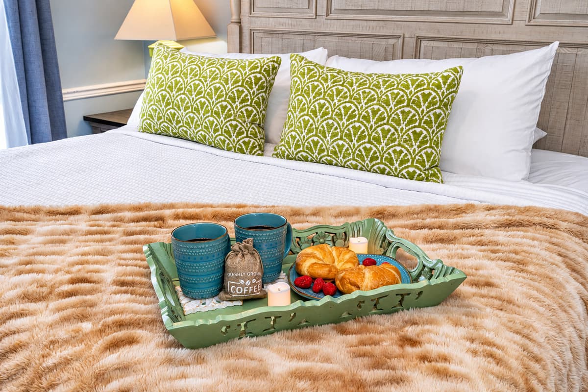 Featuring a sumptuous king-size bed with a detailed wood-paneled headboard and coordinating bedside tables.