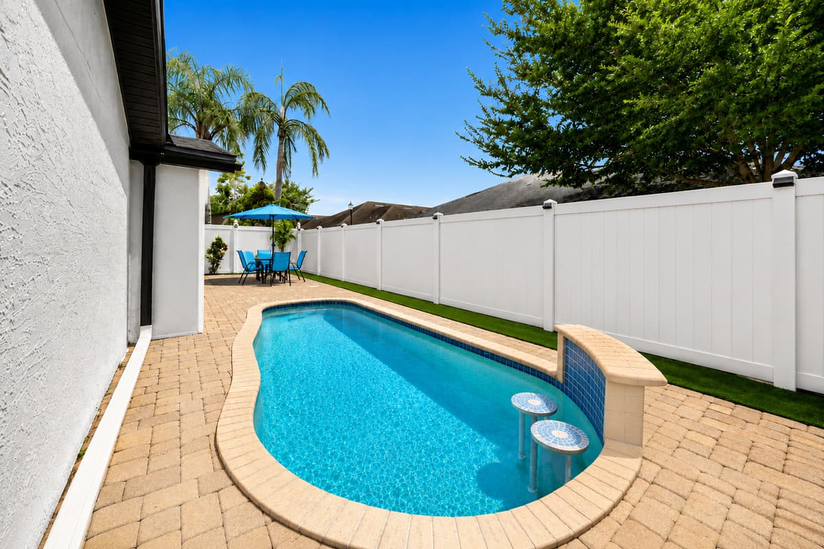 Sparkling private pool with a unique curved design, perfect for cooling off after a day of exploring Tampa's top attractions.