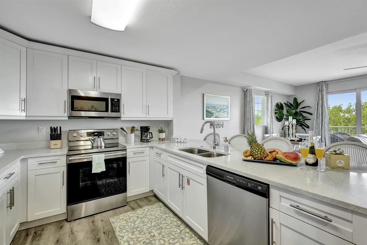 The kitchen, a space that transcends mere functionality, welcomes you with its pristine elegance and modern charm.