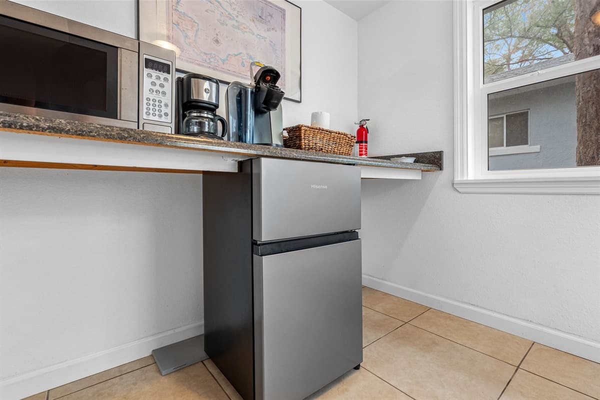 The kitchenette is equipped with all the essentials you might need, including a compact refrigerator to store your food and drinks, a microwave for quick meals, and a coffee maker to ensure you can enjoy your favorite hot beverages at any time.