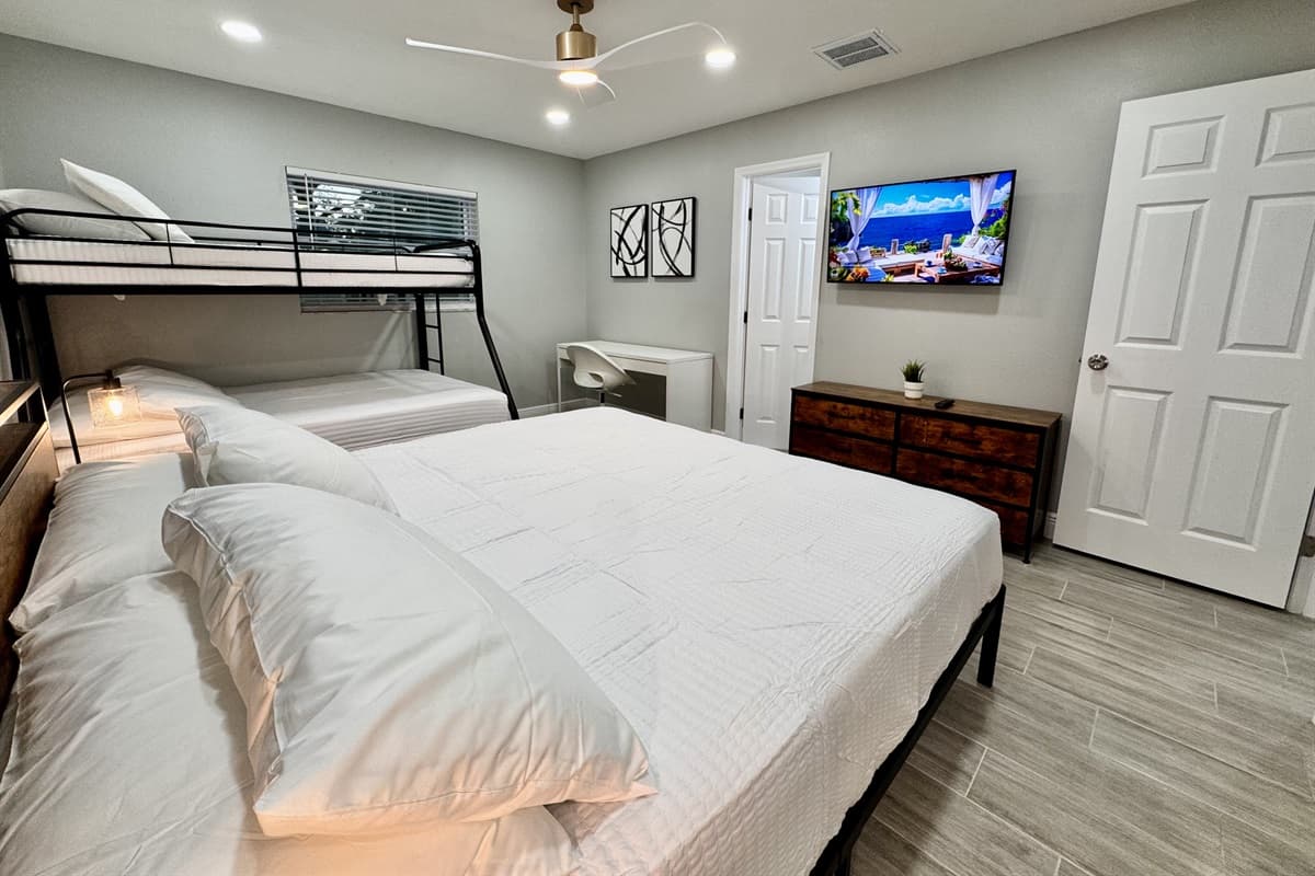 This cozy yet spacious room features a unique sleeping arrangement with a sturdy bunk bed and a plush king-size bed, accommodating various sleeping needs.