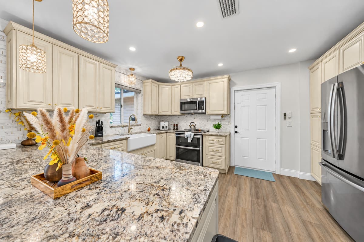 The kitchen is a true showpiece, highlighted by stunning countertops, custom cabinetry, and elegant lighting that elevates every meal.