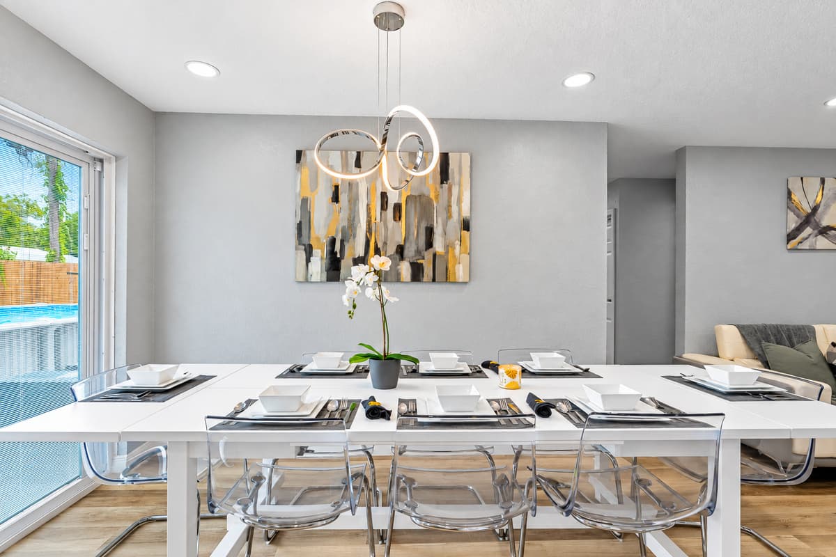 Sunlight pours over the dinner table. The long dining table sits beside big sliding doors with views of the pool. Breakfasts linger here, and holiday dinners feel like an event.