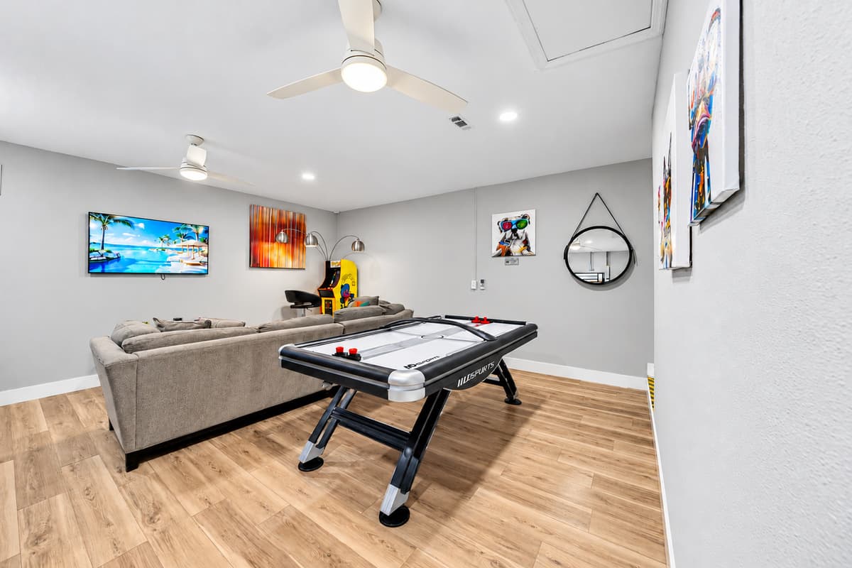 Open-concept game room with Smart TV, air hockey table, and plenty of seating.