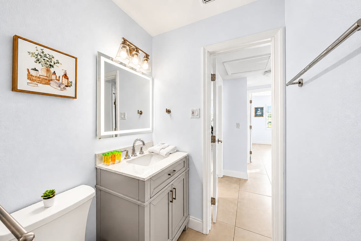 Bathroom 2 featuring a modern vanity, fresh décor, and hallway access.